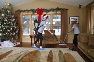 A couple is doing holiday cleaning because they are expecting a special guest.