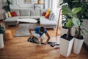 A woman is vacuuming as part of her new year cleaning routine.