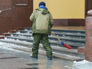 A snow removal expert is performing commercial cleaning in high-traffic areas, such as the entrance.