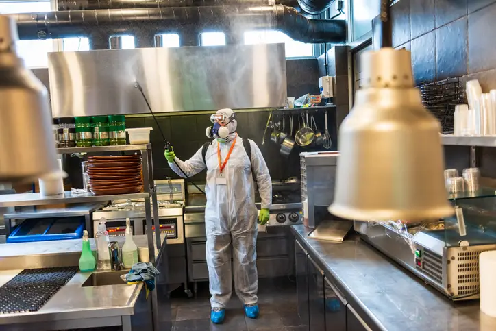Expert cleaners are disinfecting the commercial kitchen to ensure it is clean and safe during the busy season.