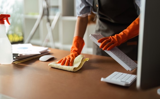 A professional is doing commercial cleaning to reduce sick days and promote a healthier work environment.