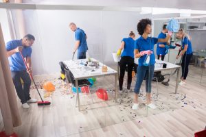 A group of professional cleaners is providing post-event cleaning services.