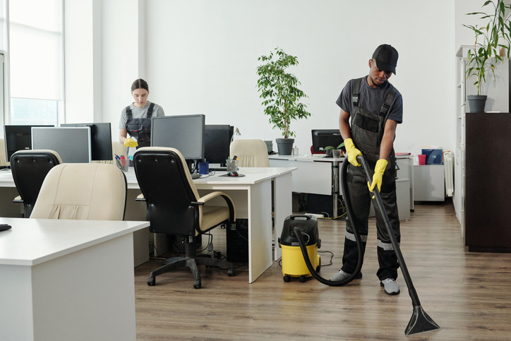 A professional cleaner mopping high-traffic office floors, illustrating the labor and property size factors that determine how much does a commercial cleaning service cost.