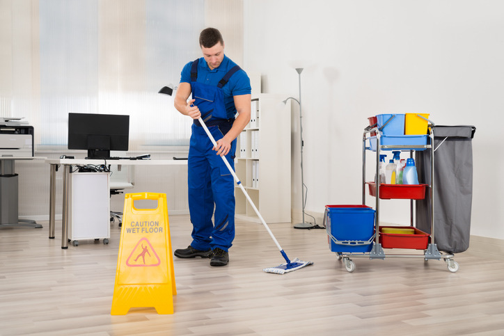 A professional cleaner mopping an office floor, demonstrating high standards to look for when learning how to choose a commercial cleaning service for your business.