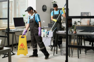 Commercial cleaning team working in an office environment illustrating commercial cleaning vs residential cleaning differences in equipment and safety practices.